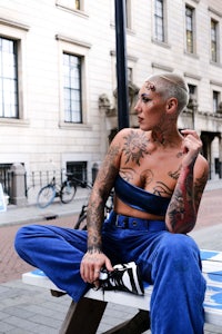 a woman with tattoos sitting on a bench