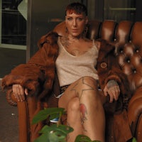 a woman sitting in a chair with tattoos