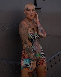a woman with tattoos posing in front of a ship