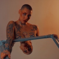 a woman with tattoos holding a mirror